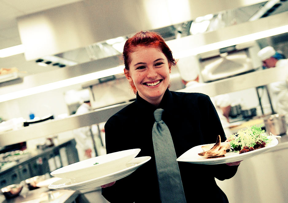 Hospitality students work front of house providing service with a smile.